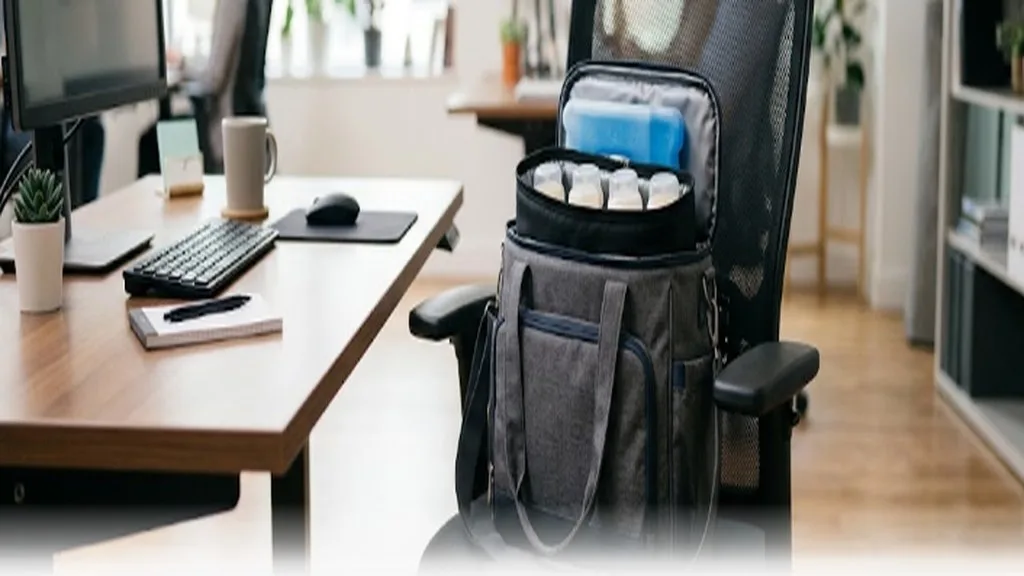 A breast pump bag with a cooler pack sitting on an office chair
