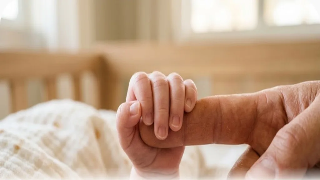 Baby's hand gripping a parent's finger, how baby grasp develops from reflex to pincer